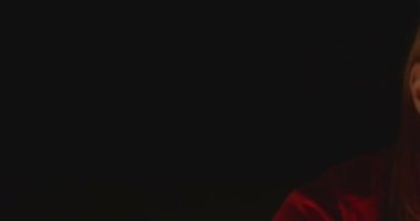 Mumlarda kızıl saçlı bir kadının portresi. Ortamı ve karanlığı aydınlatıyor..