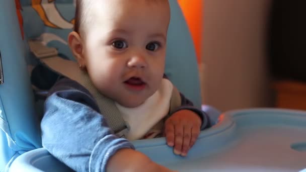 Baby zittend in de stoel voeding — Stockvideo