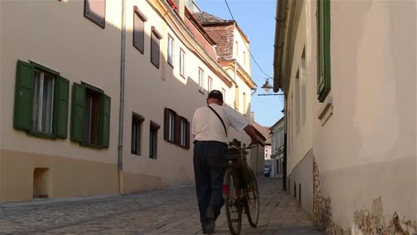 Hombre con bicicleta en la calle pavimentada — Vídeo de stock