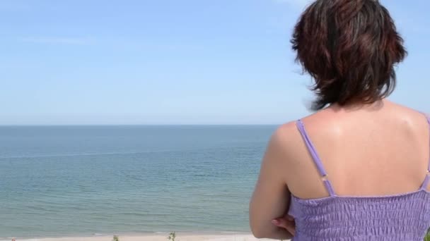 Mujer está mirando hacia el horizonte del mar — Vídeos de Stock