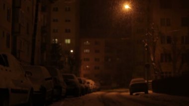 Arabalar ve cadde üzerinde gece kar yağışı