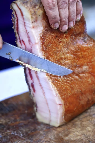 Corte de bacon em um talho — Fotografia de Stock