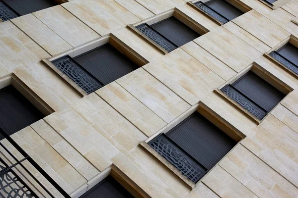 Şehirdeki taşlı bir cephede kapalı panjurlar.