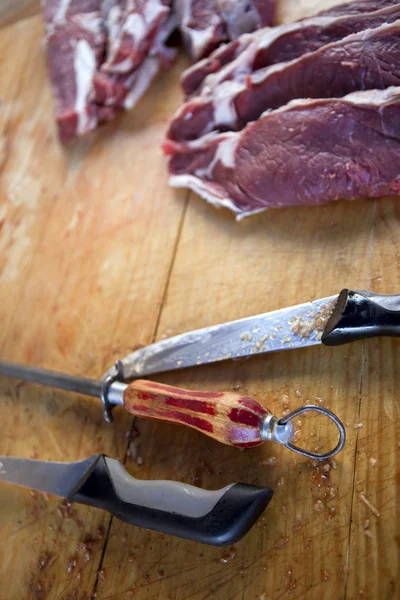 Carne y cuchillos en un puesto de carnicería — Foto de Stock