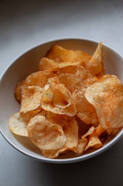 Kırmızı biber ve biber cipsi beyaz bir kasede.