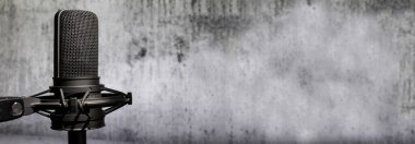 Beton duvar zemininde profesyonel mikrofon, kopyalama alanı, yayın veya podcast arkaplanı olan kentsel ses kayıt pankartı