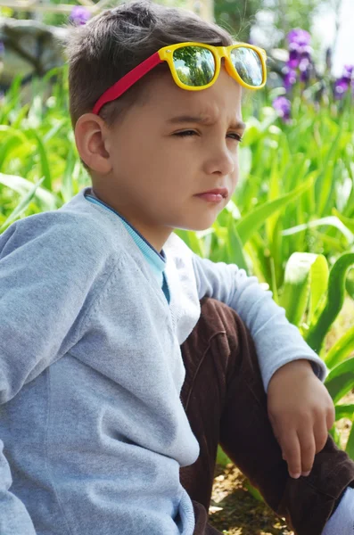 Küçük şirin çocuk güneş gözlüğü gibi gerçek bir Model oturuyor