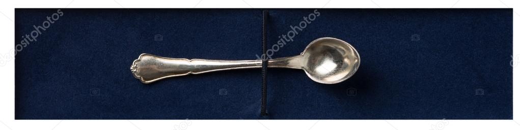 Silver spoon on blue velvet