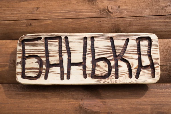 The inscription "bathhouse" on the plate on a wooden background — Stock Photo, Image