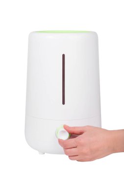 Bir kadının eli nemlendiriciyi ayarlar. Hava nemlendirici beyaz sırtüstü izole edildi