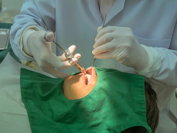 Dentist was injecting the patient's gums.