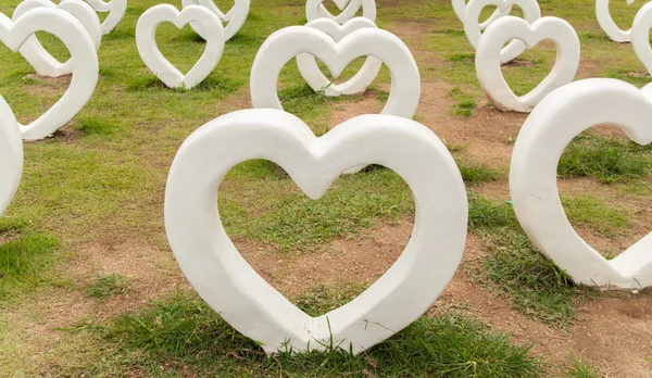 정원에서 많은 백색 심장 동상. — 스톡 사진
