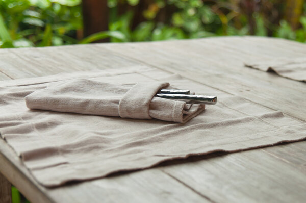 Серебро в складной чистой ткани на роскошном столе
