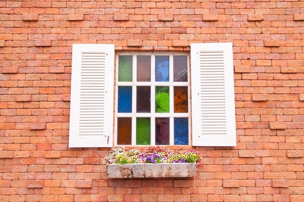 Beautiful wood window with multicolour glass and brick wall