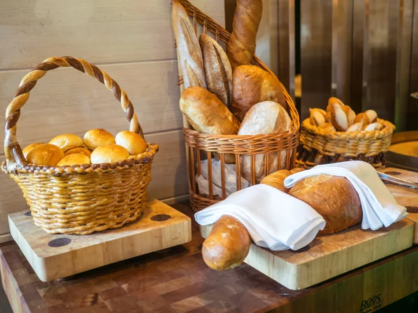 Pão fresco em placa de madeira ou cesta — Fotografia de Stock