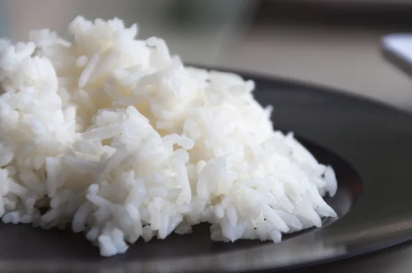 Rice on black plate — Stock Photo, Image