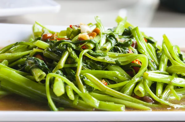 Quick-fried water spinach with chili and soy sauce  on white pla — Stock Photo, Image