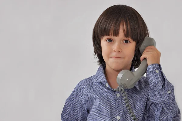 yalnız küçük çocuk telefonda konuşuyor.