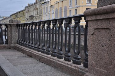 Nehir kenarındaki eski siyah metal çit. Sur boyunca şehrin etrafında yürüyorum.
