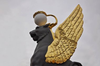 Gökyüzüne karşı altın kanatları olan siyah bir griffon. Turizm ve eğlence konsepti