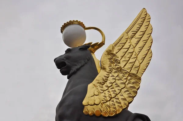 Gökyüzüne karşı altın kanatları olan siyah bir griffon. Turizm ve eğlence konsepti