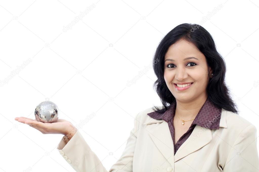 Young Indian business woman holding puzzle globe against white