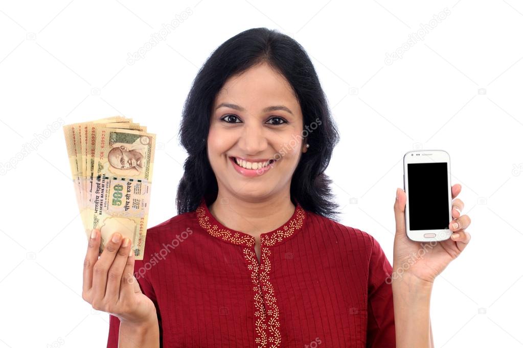 Young woman holding Indian currency and mobile phone