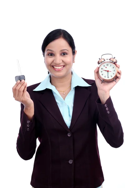 Young business woman holding alarm clock and key — Stock Photo, Image