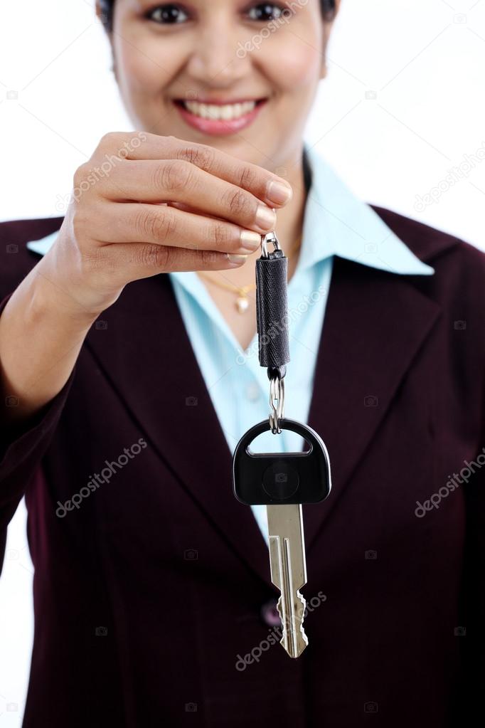 Happy young business woman holding key 