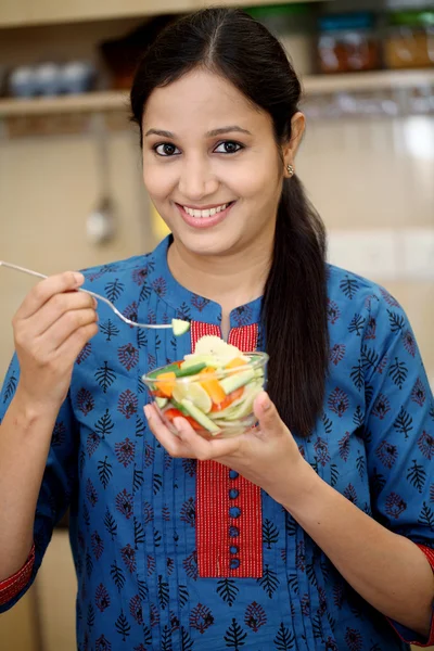 Sorrindo jovem indiana comendo salada de frutas — Fotografia de Stock