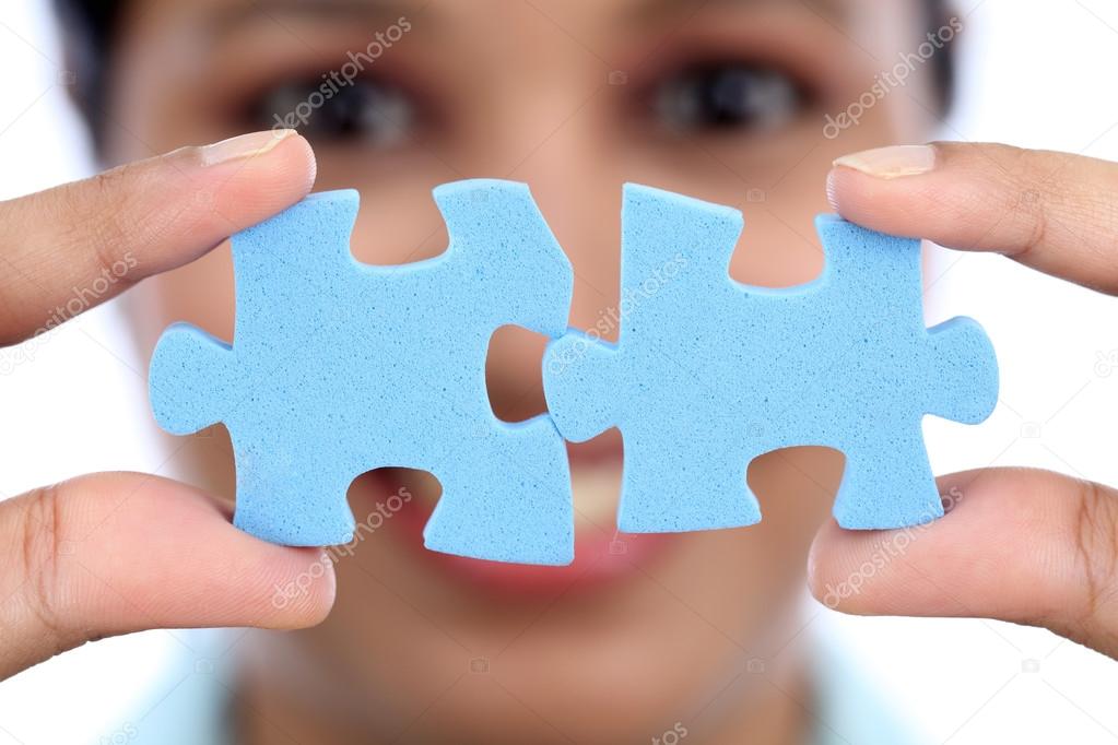 Business woman joining two jigsaw puzzle pieces