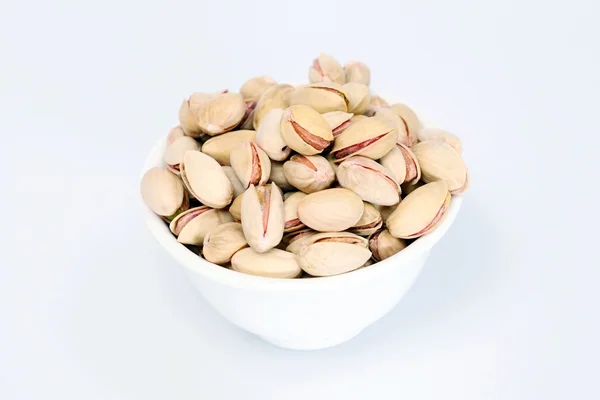 Bowl of pistachios on white — Stock Photo, Image