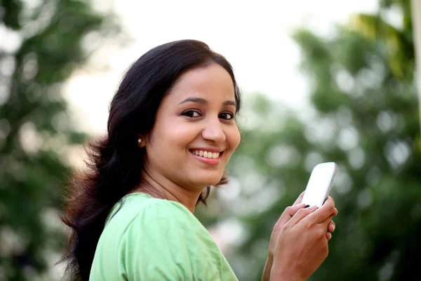 Glückliche junge Frau SMS im Freien — Stockfoto