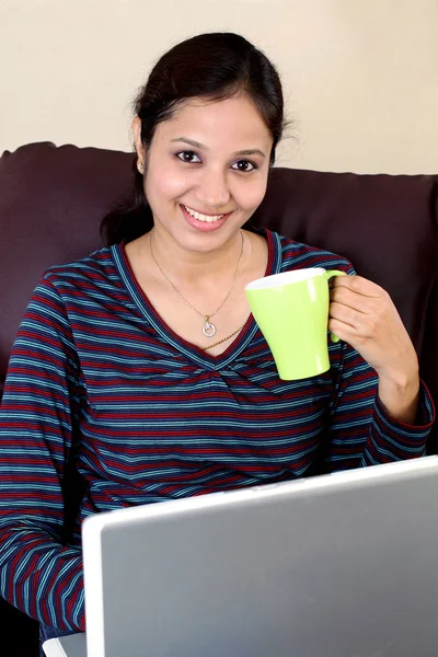 Ευτυχισμένη γυναίκα πίνοντας καφέ ενώ εργαζόταν σε φορητό υπολογιστή — Φωτογραφία Αρχείου