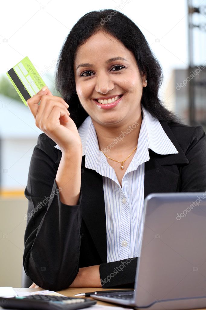 Happy young business woman holding credit card