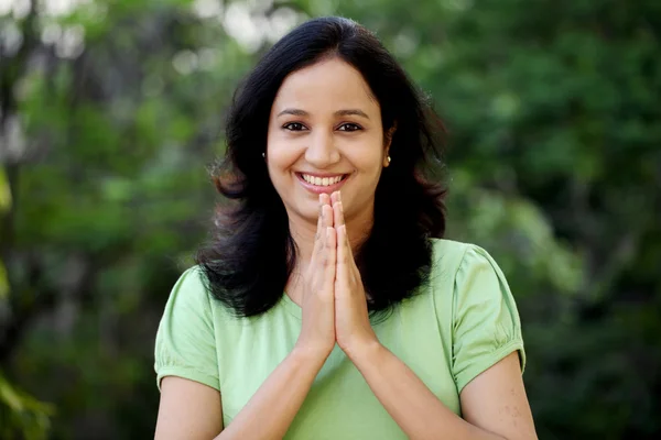 Felice giovane donna saluto con gesto "Namasthe" — Foto Stock