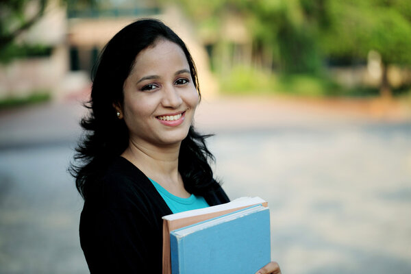 Happy young female student at college campus