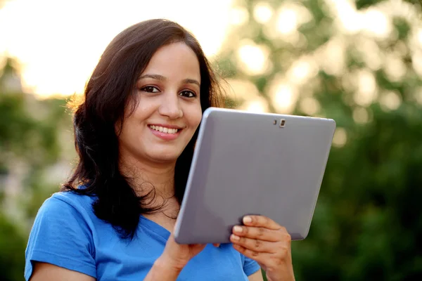Молода жінка використовує планшетний комп'ютер на відкритому повітрі — стокове фото