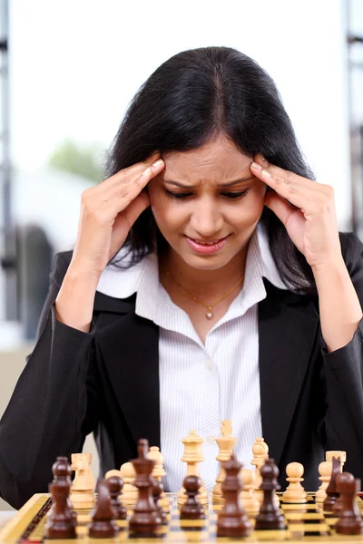 Stressed business woman playing the chess game — Stock Photo, Image