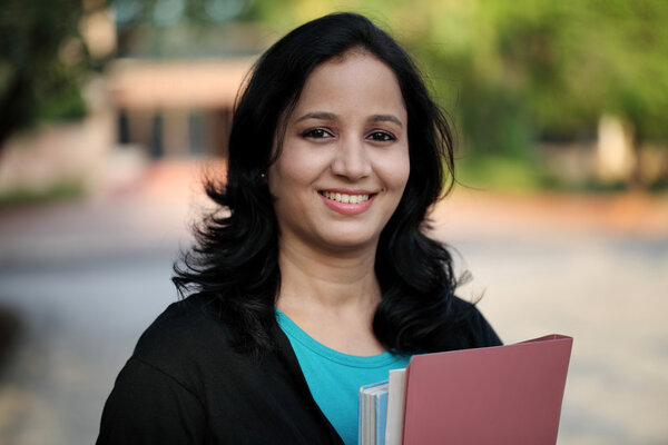 Happy young female student at college campus