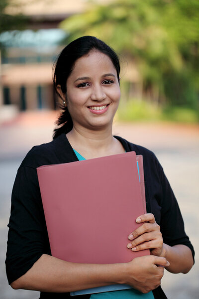 Happy young female student at college campus