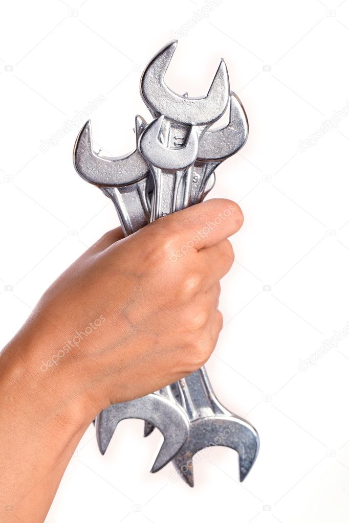 Hand holding spanners on white