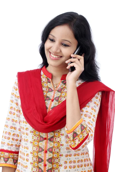 Beautiful young woman talking on mobile phone against white — Stock Photo, Image