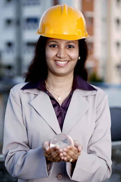 Жінка-будівельник тримає глобус — стокове фото