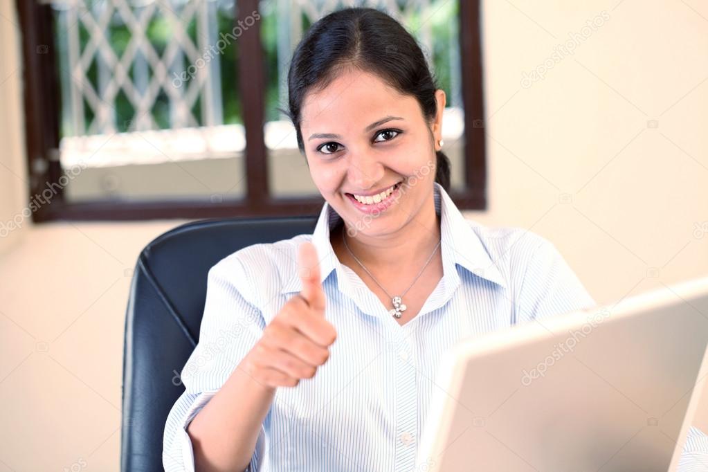 Young business woman showing thumbs up