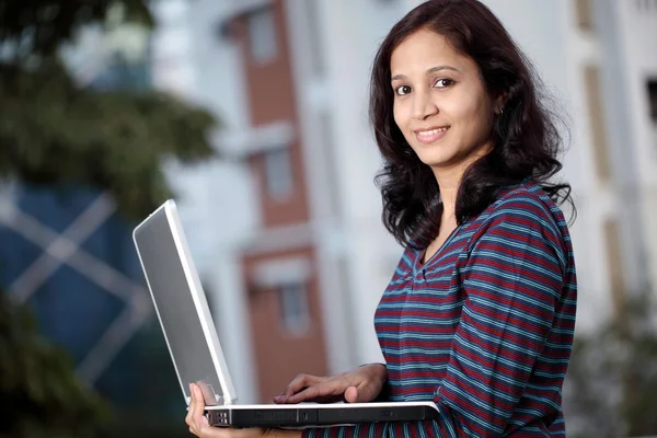 Dizüstü bilgisayar ile gülümseyen kadın üniversite öğrencisi — Stok fotoğraf