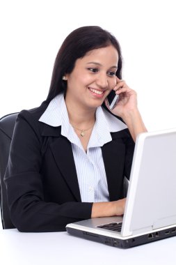 Mutlu genç iş kadını cep telefonuyla konuşuyor.