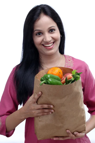 Bakkal çantası ile dolu meyve ve v tutan genç Hintli kadın