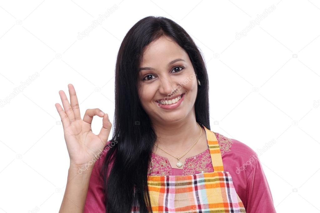 Happy young Indian woman wearing kitchen apron