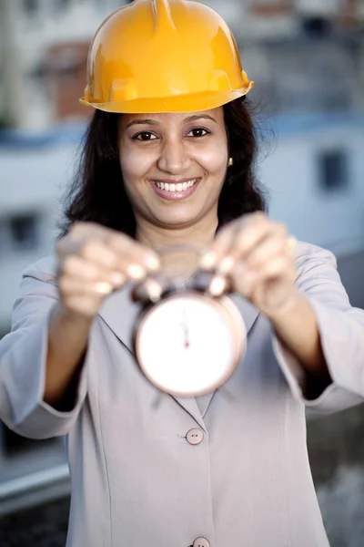 Ingeniera de construcción sosteniendo reloj despertador —  Fotos de Stock